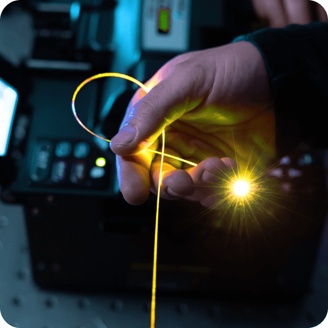 Human hand holding light yellow fibre shining in the end.